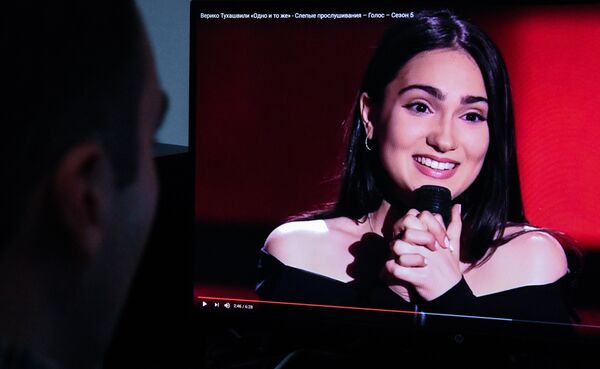 Мужчина смотрит выступление Верико Тухашвили на проекте Голос - Sputnik Грузия