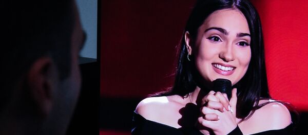 Девушка смотрит выступление Верико Тухашвили на проекте Голос - Sputnik Грузия