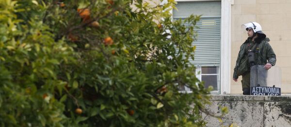 Сотрудник полиции охраняет здание парламента Греции - Sputnik Грузия