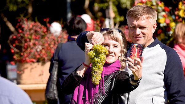 Туристы на празднике Тбилисоба делают селфи с виноградом - Sputnik Грузия