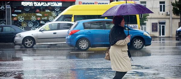 Женщина с зонтом переходит дорогу в дождь - Sputnik Грузия