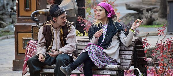 Молодые люди в старинной одежде беседуют на улице в историческом центре столицы Грузии - Sputnik Грузия