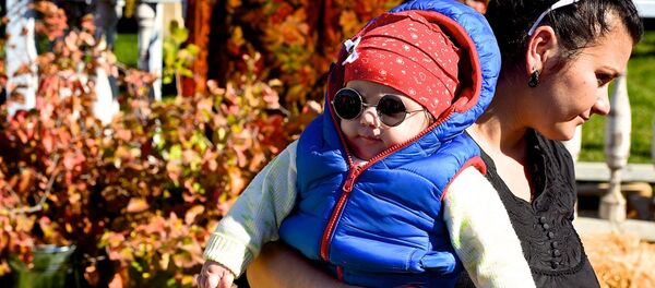 Женщина несет ребенка на руках - Sputnik Грузия