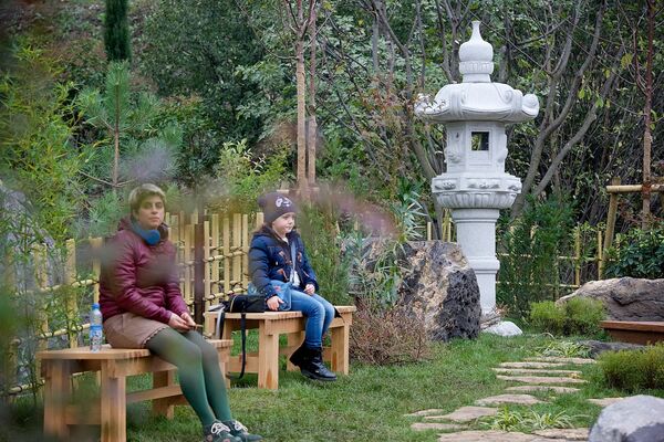 В Японском саду тихо - люди сидят на скамеечках и созерцают окружающую действительность - Sputnik Грузия