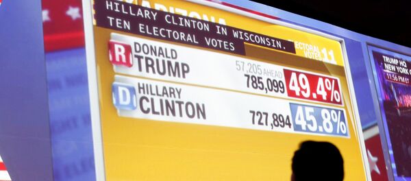 Человек наблюдает за показом данных в ходе подсчета голосов на выборах президента США - Sputnik Грузия