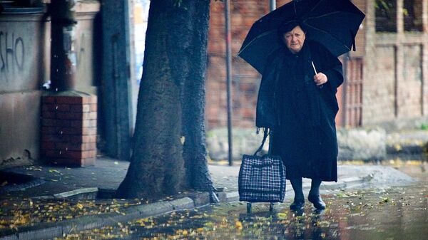 Женщина идет дождливым утром по грузинской столице - Sputnik Грузия