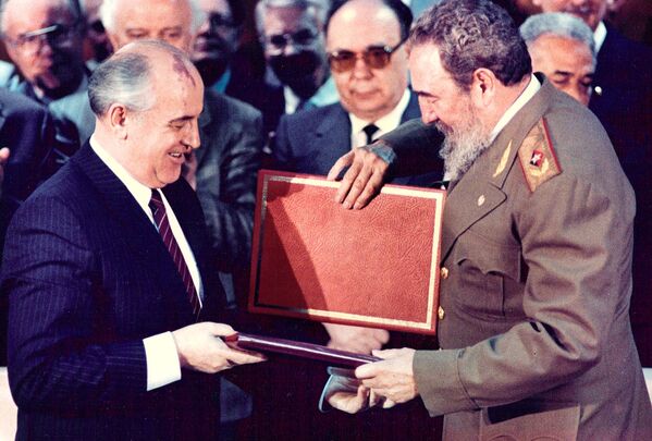 Лидер Кубы Фидель Кастро и единственный за историю СССР президент Советского Союза Михаил Горбачев обмениваются документами на торжественной церемонии в Гаване в апреле 1989 года - Sputnik Грузия