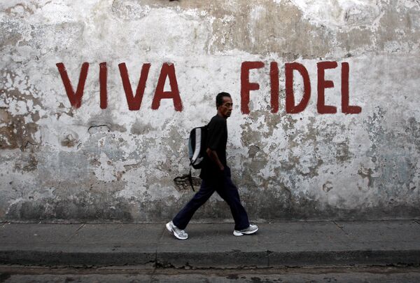 Прохожий в Сантьяго-де-Куба идет мимо дома, на стене которого написано Да здравствует Фидель! - Sputnik Грузия