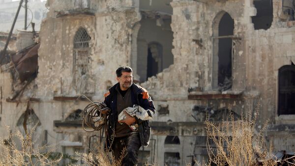 Мужчина, вернувшийся чтобы осмотреть свой дом, идет по контролируемой правительством территории в старом городе Алеппо, Сирия - Sputnik Грузия