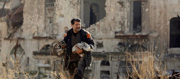 Мужчина, вернувшийся чтобы осмотреть свой дом, идет по контролируемой правительством территории в старом городе Алеппо, Сирия - Sputnik Грузия