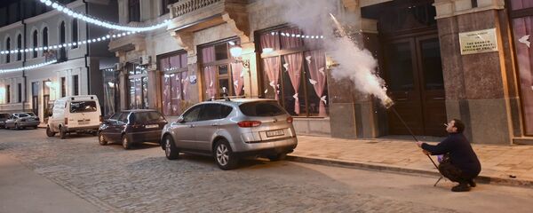 Мужчина с помощью салютной установки запускает в небо фейерверк на проспекте Агмашенебели Мужчина с помощью салютной установки запускает в небо фейерверк на проспекте Агмашенебели - Sputnik Грузия