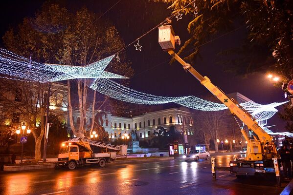 Рабочие занимаются установкой и подключением праздничной иллюминации на улицах Тбилиси практически в беспрерывном режиме. На фото - монтаж новогоднего освещения на проспекте Руставели - Sputnik Грузия