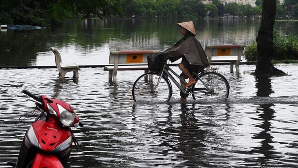 Женщина едет на велосипеде по пострадавшему от наводнения парку в Ханое, Вьетнам - Sputnik Грузия