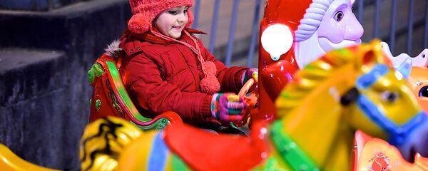 Ребенок на новогодней карусели у елки на проспекте Руставели в центре грузинской столицы - Sputnik Грузия