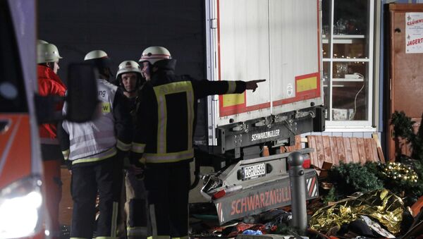 Пожарные стоят позади грузовика, который врезался в людей у рождественской ярмарки в Берлине - Sputnik Грузия