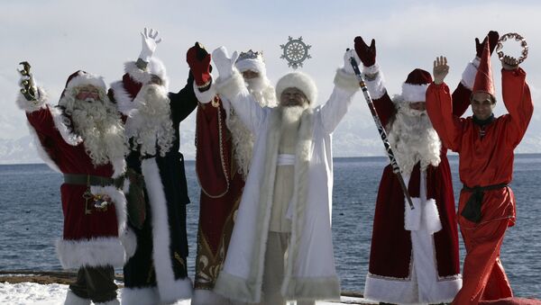 Актеры в костюмах шести Дедов Морозов со всего мира, включая (слева направо) Санта Клауса, Аяз_Ата из Казахстана, из Кыргызстана, российского Деда Мороза, иранского Хаджи Фируз, позируют на фоне озера Иссык-Куль - Sputnik Грузия