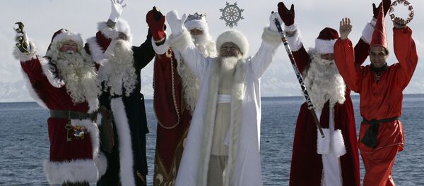 Актеры в костюмах шести Дедов Морозов со всего мира, включая (слева направо) Санта Клауса, Аяз_Ата из Казахстана, из Кыргызстана, российского Деда Мороза, иранского Хаджи Фируз, позируют на фоне озера Иссык-Куль - Sputnik Грузия