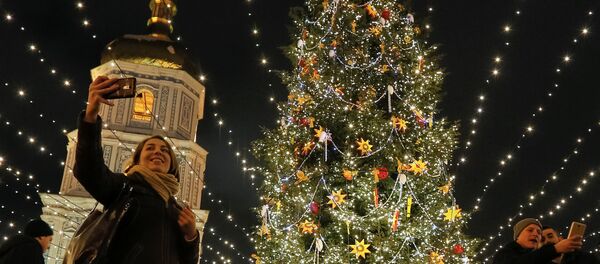 Люди фотографируются рядом с новогодней елкой в центре Киева, Украина - Sputnik Грузия