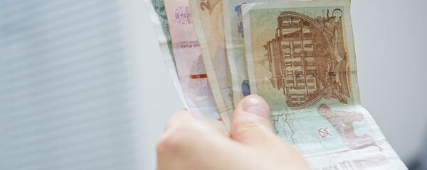 Человек держит в руках купюры грузинской валюты лари различного номинала - Sputnik Грузия