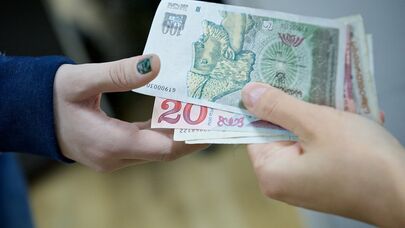 Люди передают друг другу купюры грузинской валюты лари различного номинала