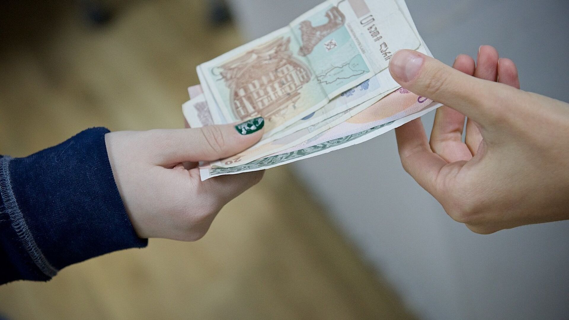 Люди передают друг другу купюры грузинской валюты лари различного номинала - Sputnik Грузия, 1920, 18.03.2023