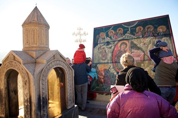 Люди у иконы Рождения Христа на территории храма Святой Троицы Самеба, после завершения шествия Алило - Sputnik Грузия