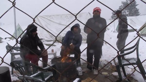 Беженцы грелись у костра в занесенном снегом лагере мигрантов в Салониках - Sputnik Грузия