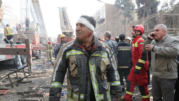 Пожарный на месте рухнувшего высотного здания в Тегеране, Иран - Sputnik Грузия