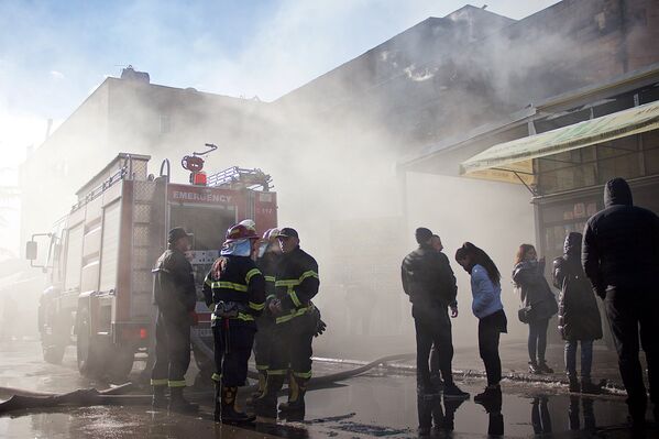 Пожарные и сотрудники торгового центра у входа в здание, которое практически полностью было уничтожено пожаром - Sputnik Грузия