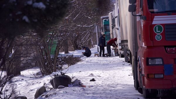 Водители грузовых фур греются у машин в ожидании начала пропуска по горной дороге - Sputnik Грузия