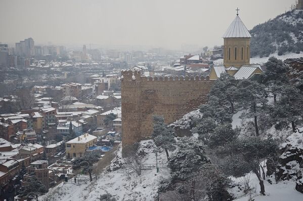 Снег преображает исторический центр Тбилиси, который в ясную и солнечную погоду более привычен взгляду. На фото - крепость Нарикала и купол церкви Святого Георгия - Sputnik Грузия