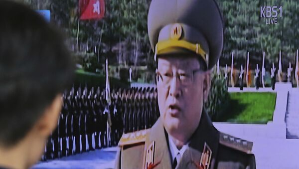 Мужчина смотрит на трансляцию выступления министра госбезопасности Северной Кореи Ким Вон Хона - Sputnik Грузия