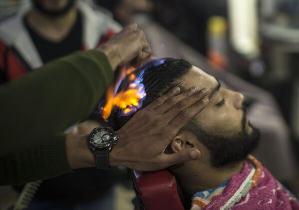 Парикмахер делает это либо при помощи газового баллона, расчесывая волосы под прямой струей огня, либо огонь полыхает прямо по волосам - Sputnik Грузия