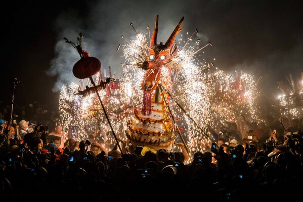 Огненный дракон, сделанный из петард, китайских фонариков и фейерверков во время исполнения праздничного танца дракона участниками Фестиваля фонарей в провинции Гуандун в Китае - Sputnik Грузия