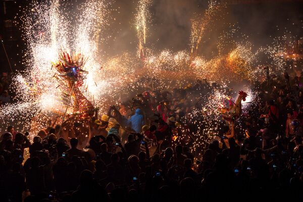 Люди смотрят на огненные фигуры дракона и петуха, сделанные из фонариков, петард и фейерверков во время исполнения праздничных народных танцев на Фестивале фонарей в уезде Феншун (провинция Гуандун, Китай) - Sputnik Грузия