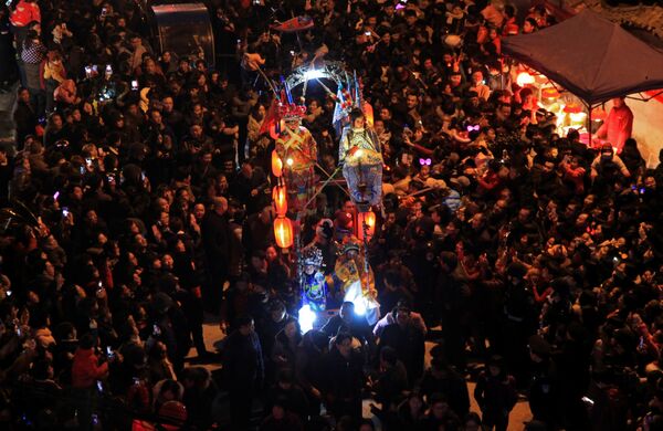 Традиционное праздничное шествие во время проведения Фестиваля фонарей в городе Нинбо, провинция Чжэцзян. Во время шествия его участники исполняют народные танцы и держат в руках фонарики и огненные светильники - Sputnik Грузия