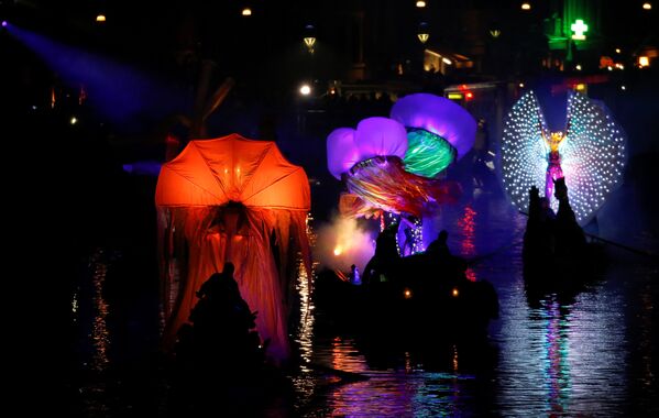 Группа артистов показывает световое шоу на лодках и гондолах на открытии  традиционного карнавала в Венеции. Венецианский карнавал, который проводится ежегодно - один из старейших в мире. Чтобы поучаствовать в мероприятии и посмотреть, как проходит карнавал, в Венецию съехались сотни тысяч туристов со всего мира. - Sputnik Грузия