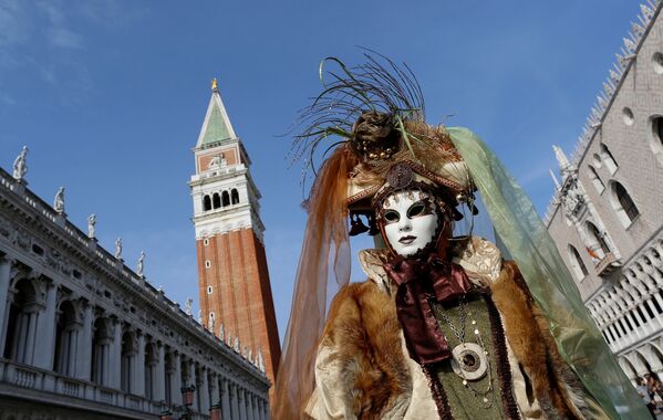 Ношение масок в Венеции было очень популярно на протяжении полугода, с августа до Великого поста. На фото - одна из участниц карнавала прогуливается по центру города в маскарадном костюме - Sputnik Грузия