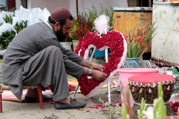 Мужчина составляет букет в форме сердца в День Святого Валентина на цветочном рынке в Исламабаде, Пакистан - Sputnik Грузия