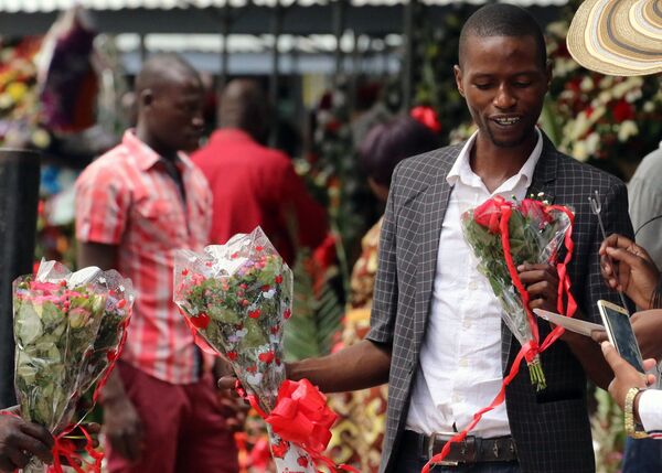 Мужчина выбирает в подарок букет в День Святого Валентина на цветочном базаре в городе Хараре, Зимбабве - Sputnik Грузия