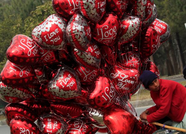 Мальчик продает воздушные шары в форме сердца с надписью Я люблю тебя в День Святого Валентина на цветочном базаре в Исламабаде, Пакистан - Sputnik Грузия