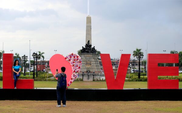 შეყვარებულები სამახსოვრო ფოტოს იღებენ უზარმაზარ წარწერასთან LOVE (სიყვარული) მანილში, ფილიპინები - Sputnik საქართველო