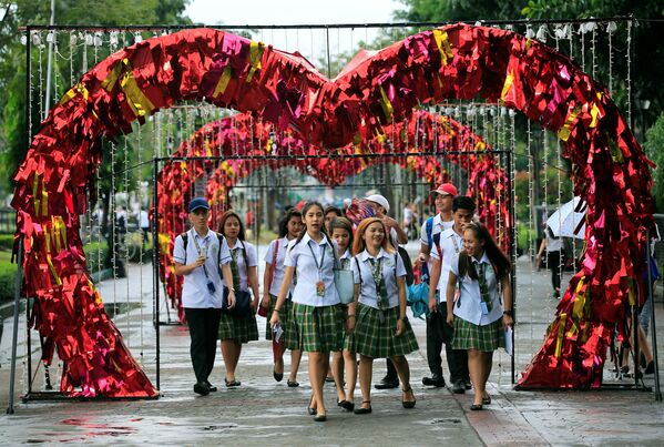Студенты гуляют по празднично украшенному Лунета-парку в День Святого Валентина в Маниле, Филиппины - Sputnik Грузия