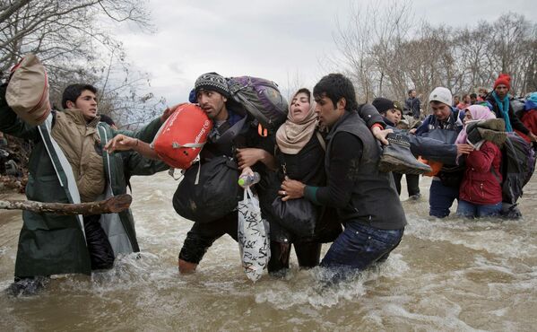 Беженцы пересекают реку, пытаясь добраться до Македонии в обход пограничных пунктов пропуска. Это фото Вадима Гирда из Associated Press завоевало вторую премию World Press Photo Awards 2017 в категории Современные проблемы - Sputnik Грузия