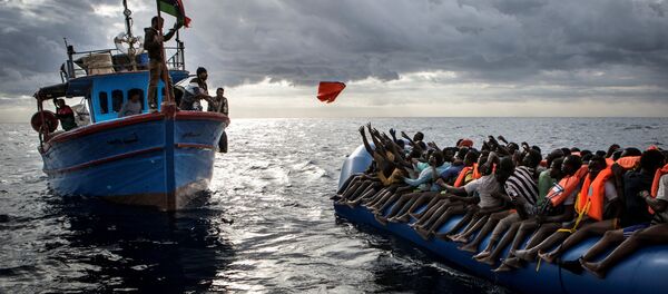 Ливийские рыбаки бросают спасательные жилеты мигрантам, которых контрабандисты, организовавшие переправу, направили в открытое море на резиновой лодке к берегам Италии. Это фото Мэтью Уилкока из MOAS.eu, сделанное в серии “Средиземноморская миграция”, завоевало третью премию World Press Photo Awards 2017 в категории “Экстренные новости” - Sputnik Грузия