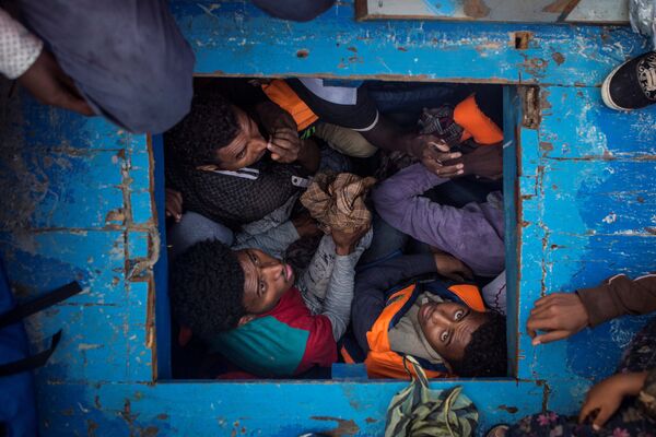 Беженцы из Эритреи, небольшого государства в восточной Африке, сидят в трюме деревянной лодки, пытаясь по Средиземному морю добраться до берегов Европы. На этой лодке перевозили 540 мужчин, женщин и детей. Это фото Мэтью Уилкока из MOAS.eu, сделанное в серии “Средиземноморская миграция”, завоевало третью премию World Press Photo Awards 2017 в категории “Экстренные новости” - Sputnik Грузия