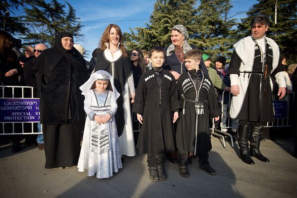 Православные верующие вместе со своими детьми в грузинской национальной одежде встречают Патриарха всея Грузии Илию II в тбилисском аэропорту - Sputnik Грузия