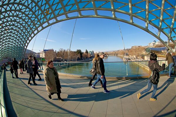 Прохожие на мосту Мира в центре Тбилиси февральским вечером - Sputnik Грузия