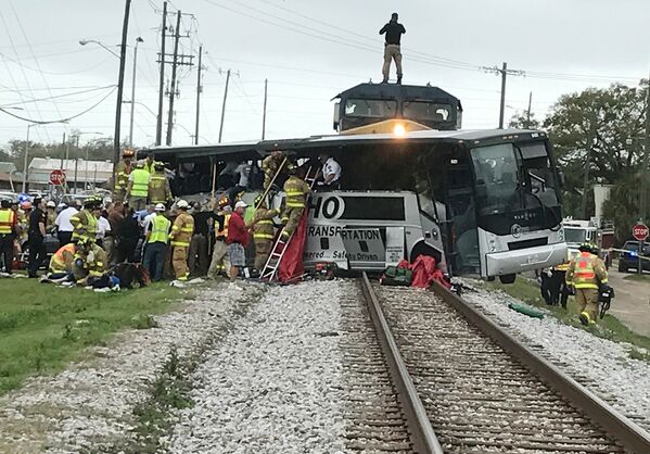 Пожарные и спасатели штата Миссисипи помогают людям выбраться из автобуса, после того, как в него врезался поезд, направлявшийся в Остин, Техас - Sputnik Грузия
