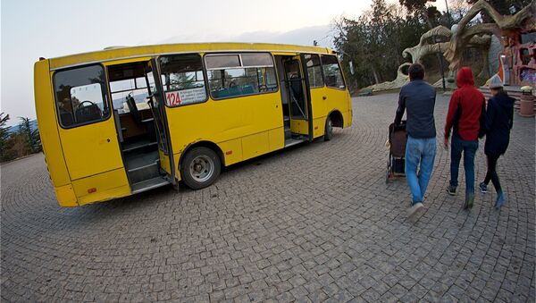 Люди идут к автобусу на стоянке общественного транспорта у парка Мтацминда - Sputnik Грузия